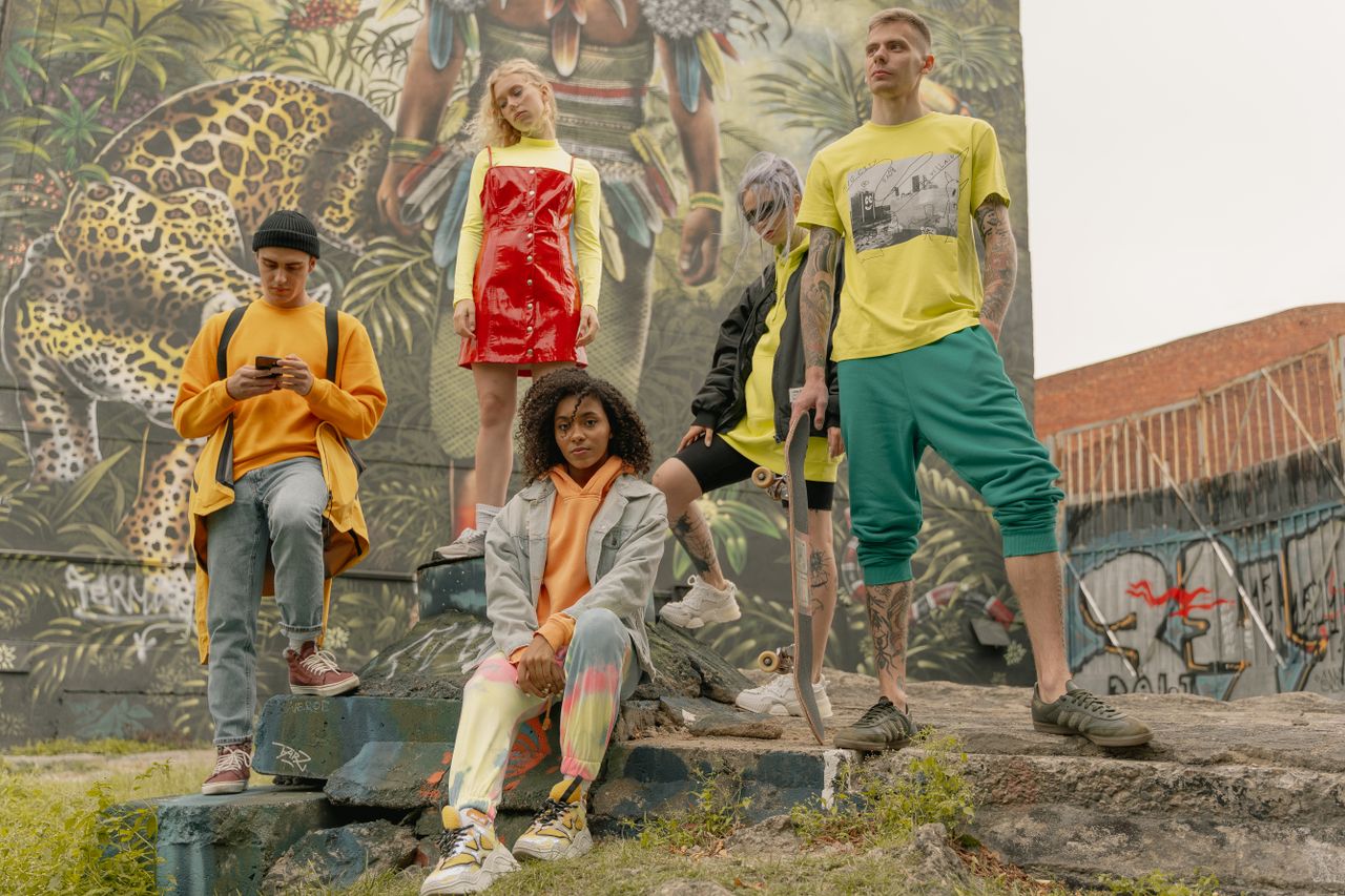 The Art of Drawing Readers In: Your attractive post title goes here Fashionable group of young adults posing stylishly with skateboards against a vibrant street art backdrop.